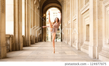 Ballerina performing high leg extension in archway Ballerina performing high leg extension in archway 124977875