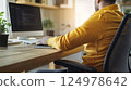 Young Professional Working on Laptop in Modern Office, Programming, Coding, with Plant 124978642
