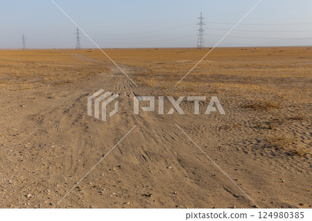 Kunduz Province landscape with electric towers and a dirt path through dry terrain in Afghanistan Kunduz Province landscape with electric towers and a dirt path through dry terrain in Afghanistan 124980385