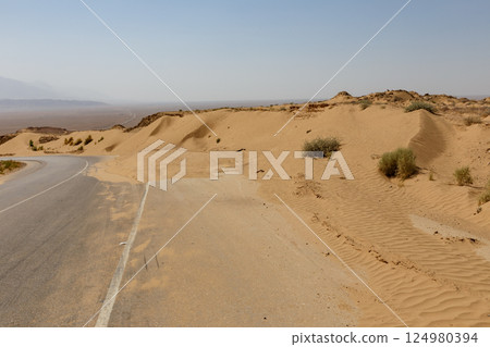 Road from Kunduz to Kholm in Afghanistan showcasing desert landscape and surroundings 124980394