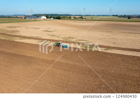 Drone aerial view of a tractor working an agricultural field in Germany 124980430