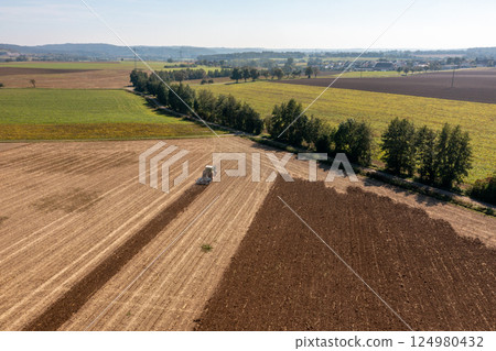 Drone view of a tractor plowing an agricultural field in Germany Drone view of a tractor plowing an agricultural field in Germany 124980432