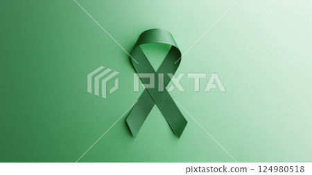 Mental Health Awareness Concept. Self Care, Positive Thinking, Happy and Optimistic Mind. a Green Ribbon lay on Green background. Table top view 124980518