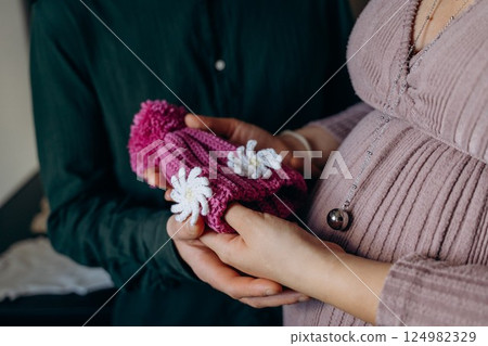 Expectant Couple Holding Baby Clothes in Anticipation Expectant Couple Holding Baby Clothes in Anticipation 124982329