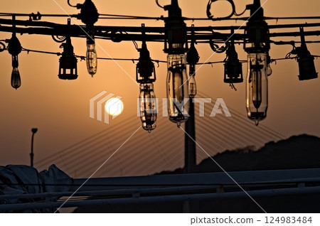 Silhouette of the lamp of an anchored squid fishing boat Silhouette of the lamp of an anchored squid fishing boat 124983484