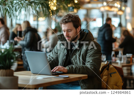Focused man working on laptop in cozy urban lifestyle photography productivity and relaxation 124984861