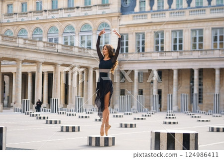 Graceful Ballerina Posing in Historic Paris Courtyard with Elegant Charm Graceful Ballerina Posing in Historic Paris Courtyard with Elegant Charm 124986411