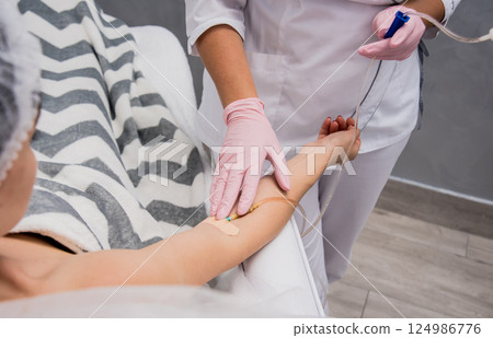The doctor cosmetologist makes cosmetology dropper procedure. Infusion.  124986776