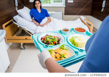 Nurse in medical coat is holding a tray with breakfast Nurse in medical coat is holding a tray with breakfast 124986820