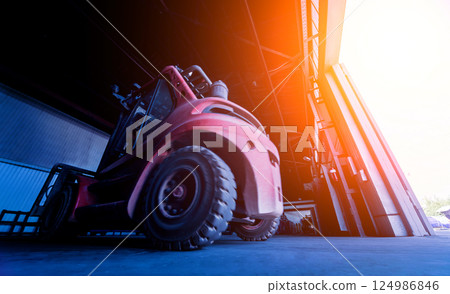 The big industrial forklift drives into the warehouse. The big industrial forklift drives into the warehouse. 124986846