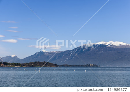 Lake Garda on a sunny spring morning in Italy surrounded by alpine peaks Lake Garda on a sunny spring morning in Italy surrounded by alpine peaks 124986877