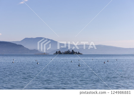 San Biagio island on Lake Garda in Italy surrounded by calm water San Biagio island on Lake Garda in Italy surrounded by calm water 124986881