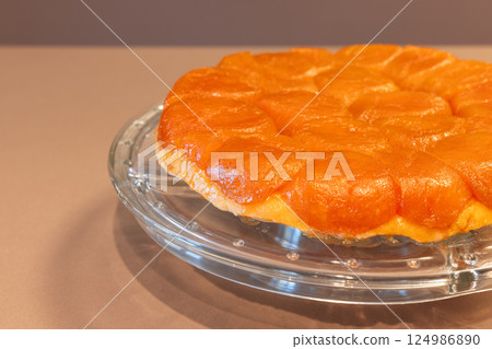 Close-up view of French Tarte Tatin with caramelized apple topping and golden crust on a glass plate 124986890