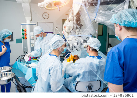 Brain surgery. Group of surgeons in operating room with surgery equipment. Brain surgery. Group of surgeons in operating room with surgery equipment. 124986901