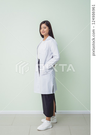 Asian woman ophtalmologist standing at hospital and looking at camera. 124986961