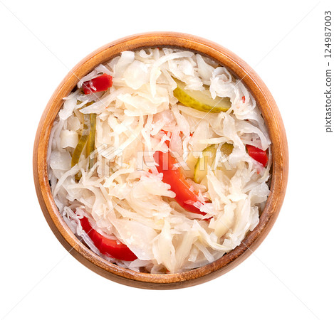 Puszta salad, pickled cabbage salad in a wooden bowl. Popular Hungarian side dish, made with thin sliced cabbage, cut gherkins, peppers, and onions, and conserved in sweet-sour white vinegar brine. 124987003