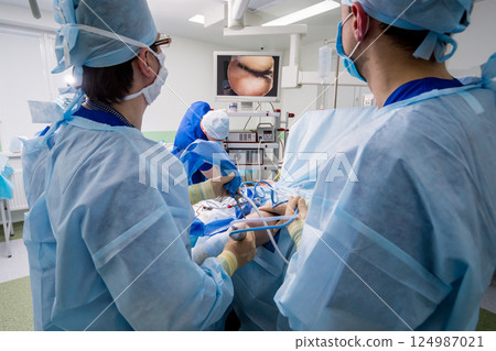 Arthroscope surgery. Orthopedic surgeons in teamwork in the operating room Arthroscope surgery. Orthopedic surgeons in teamwork in the operating room 124987021