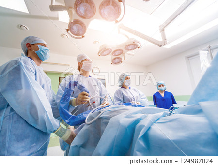 Arthroscope surgery. Orthopedic surgeons in teamwork in the operating room Arthroscope surgery. Orthopedic surgeons in teamwork in the operating room 124987024