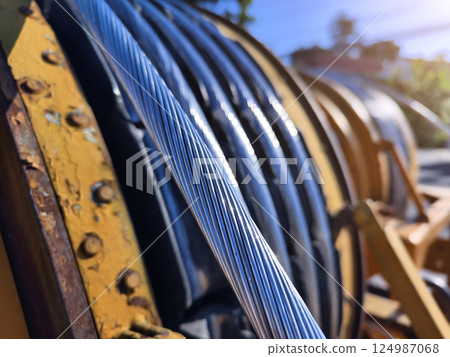 A large wooden spool of high-voltage electric wires is located on the road A large wooden spool of high-voltage electric wires is located on the road 124987068