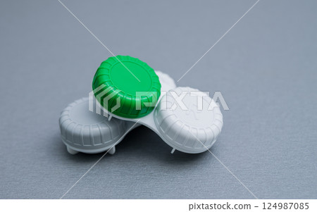 Contact lens container on a gray table. 124987085
