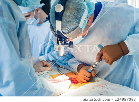 Spinal surgery. Group of surgeons in operating room with surgery equipment.  124987088