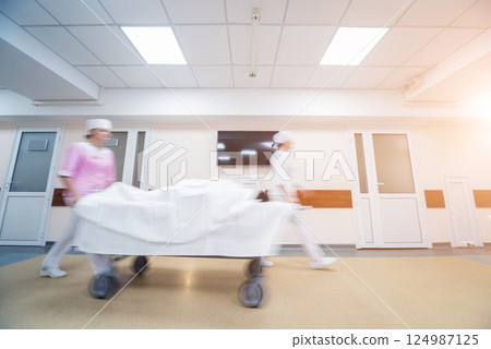 Nurses moves medical stretcher with patient at hospital. Medical equipment. 124987125