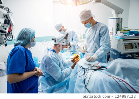 Brain surgery. Group of surgeons in operating room with surgery equipment. 124987128