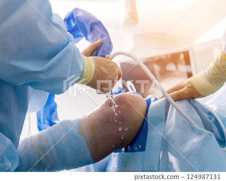 Arthroscope surgery. Orthopedic surgeons in teamwork in the operating room  124987131