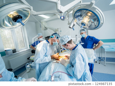 Spinal surgery. Group of surgeons in operating room with surgery equipment. Spinal surgery. Group of surgeons in operating room with surgery equipment. 124987135