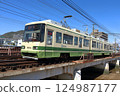 Hiroshima Electric Railway Miyajima Line tram running on a steel bridge 124987177