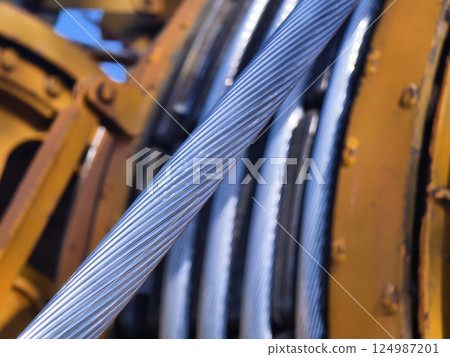 A large wooden spool of high-voltage electric wires is located on the road A large wooden spool of high-voltage electric wires is located on the road 124987201