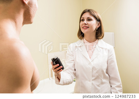 The doctor connects an insulin pump to a patient with diabetes.  124987233