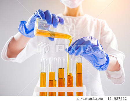 Scientist pouring organic oil. Beauty and cosmetics sciences.  124987312