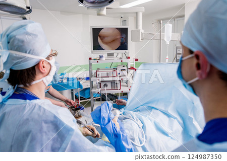 Arthroscope surgery. Orthopedic surgeons in teamwork in the operating room  124987350