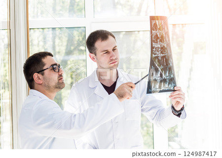 Two doctors having medical council in hospital. Discussing medical issues. Two doctors having medical council in hospital. Discussing medical issues. 124987417