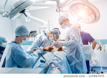 Spinal surgery. Group of surgeons in operating room with surgery equipment. Spinal surgery. Group of surgeons in operating room with surgery equipment. 124987435