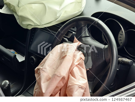 Airbag is currently hanging from the steering wheel of a car Airbag is currently hanging from the steering wheel of a car 124987467
