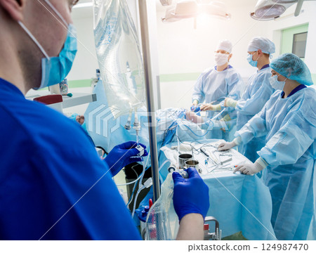 Arthroscope surgery. Orthopedic surgeons in teamwork in the operating room 124987470