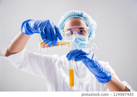 Scientist pouring organic oil. Beauty and cosmetics sciences.  124987485