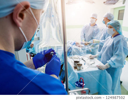 Arthroscope surgery. Orthopedic surgeons in teamwork in the operating room 124987502