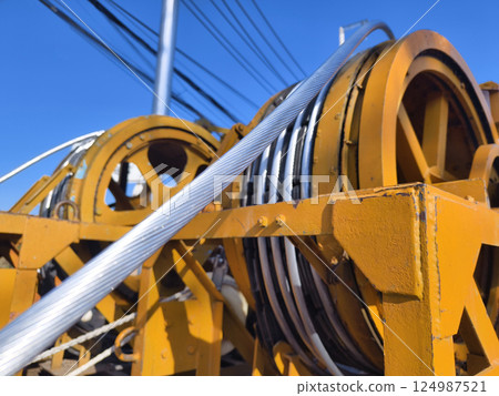 A large wooden spool of high-voltage electric wires is located on the road A large wooden spool of high-voltage electric wires is located on the road 124987521