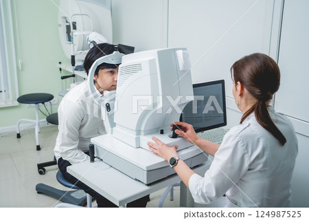 Consultation with an ophthalmologist. Young asian man and woman doctor Consultation with an ophthalmologist. Young asian man and woman doctor 124987525