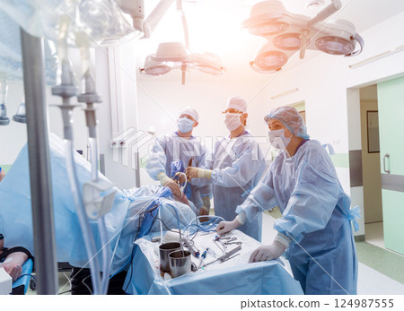 Arthroscope surgery. Orthopedic surgeons in teamwork in the operating room Arthroscope surgery. Orthopedic surgeons in teamwork in the operating room 124987555