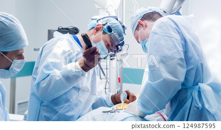 Spinal surgery. Group of surgeons in operating room with surgery equipment. Spinal surgery. Group of surgeons in operating room with surgery equipment. 124987595