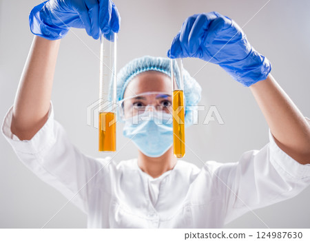 Scientist pouring organic oil. Beauty and cosmetics sciences.  124987630