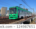 Hiroshima Electric Railway Miyajima Line tram running on a steel bridge 124987651