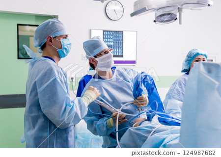 Arthroscope surgery. Orthopedic surgeons in teamwork in the operating room  124987682