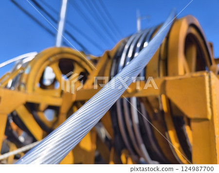 A large wooden spool of high-voltage electric wires is located on the road 124987700