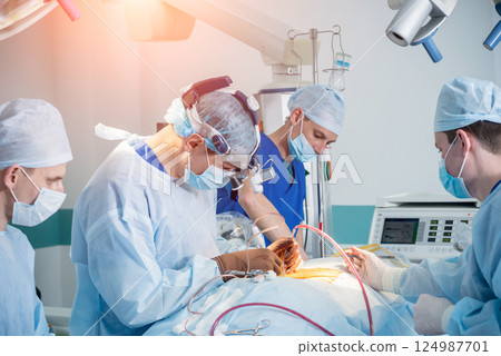 Spinal surgery. Group of surgeons in operating room with surgery equipment. Spinal surgery. Group of surgeons in operating room with surgery equipment. 124987701