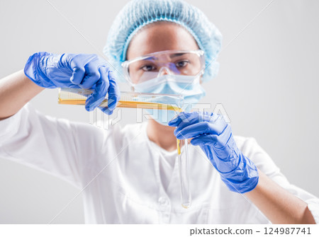 Scientist pouring organic oil. Beauty and cosmetics sciences.  124987741